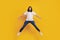 Portrait of crazy active brunet guy jump have fun on yellow background