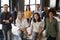 Portrait of a creative business team leaning on a desk, smiling to camera in office, elevated view