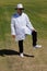 Portrait of cricket umpire signaling leg bye during match