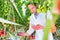 Portrait of Crop scientist using equipment to examine tomatoes growing in greenhouse