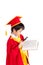 Portrait Of Curious Boy In Red Gown Kid Graduation With Mortarboard Looking A Book Through Magnifying Glass