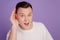 Portrait of curious eavesdropping guy hands ear listen on purple background