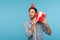 Portrait of curious man with funny party hat holding gift box near ear and listening, guessing present