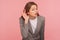 Portrait of curious nosy young woman in business suit holding hand near ear, listening carefully