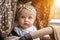 Portrait curious surprised emotional eight-month-old blue-eyes girl sitting in stroller looking away