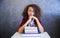 Portrait of curly hair teen girl above book