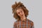 Portrait of a curly-haired young man with a wooden comb in full hair smiling on a gray isolated background. male hair care concept