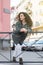 Portrait of curly-haired young woman on the street. Latin woman. Arab woman