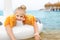 Portrait cute adorable caucasian preschooler blond girl enjoy relaxing with inflatable toy at beach of ocean or sea resort.