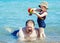 Portrait of cute adorable happy smiling toddler little girl with towel on beach making poses faces having fun