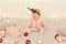 Portrait of cute adorable infant baby girl wearing sleeper and deer horns carnival hoop looking at present boxes and baubles while