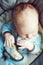 Portrait of cute adorable white Caucasian sleeping little baby boy newborn in blue clothes sitting in swing chair