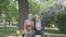 Portrait cute adult couple looking old photos remembering happy moments sitting on a bench in the park. Mature couple in