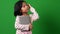 Portrait of cute Asian schoolgirl child 7-8 years looking at camera standing and holding book on the green screen background and