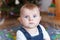 Portrait of cute baby boy of 6 months infront of Christmas tree.