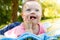 Portrait of Cute baby boy with Down syndrome lying on blanket in summer day on nature