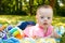 Portrait of Cute baby boy with Down syndrome lying on blanket in summer day on nature