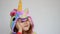 Portrait of a cute baby girl in costum unicorn smiling and playing. Child in unicorn`s pajamas smiles and plays
