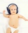 Portrait of cute baby listens to music in headphones lying