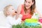 Portrait of a cute baby sitting on high chair while eating solid food