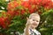 Portrait of a cute blond boy. A 5-year-old child laughs in front of a blooming Delonix regia. Place for text. Emotions