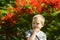 Portrait of a cute blond boy. A 5-year-old child laughs in front of a blooming Delonix regia. Place for text. Emotions