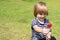 Portrait of a cute boy with candy on the background grass.