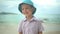 Portrait cute boy in a hat laughs on the beach.