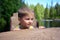 Portrait of a cute boy sits chair near edge of a river