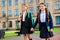 Portrait of cute buddies having rucksack backpack walking wearing black jackets blazers skirt outside college