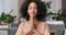 Portrait of cute calm curly girl afro american woman folds her hands in front of her touches palms to each other prays