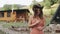 Portrait of a cute carefree young farmer woman in a cowboy hat walking on the farm in the village