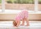 Portrait of cute Caucasian baby girl doing physical fitness exercises yoga on floor