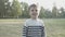 Portrait of cute Caucasian boy standing in park