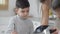 Portrait of cute charming Middle Eastern boy helping mother cooking smoothie in kitchen. Happy handsome son preparing