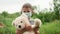 Portrait of cute child boy in blue protective face mask with bear toy in hands. Little boy holding teddy bear and waving hand, loo