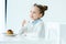 portrait of cute child with glass of milk in hand and homemade pancakes with honey and berries