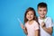 Portrait of cute children with toothbrushes on color background.