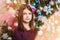 Portrait of a cute dark-haired girl on a blurring Christmas background, lights