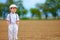 Portrait of cute farmer boy on spring field