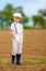 Portrait of cute farmer boy on spring field