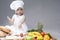 Portrait of Cute Funny Caucasian Female Cook with Lots of Vegetables In Front.