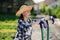 Portrait of cute gardener girl with wheelbarrow working in garden market