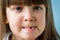 Portrait of cute girl losing her first milk tooth. Close up