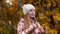 Portrait cute girl touching long hair and looking to camera in autumn forest