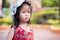 Portrait cute girl was upset wearing red dress. Adorable kid wearing white hat with polka dots to protect from the hot sun.