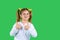 Portrait of a cute girl who shows class smiles and looks at the camera. Green background and side space.
