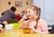 Portrait of cute happy girl with disability develops the fine motor skills at rehabilitation center for kids with special needs