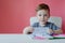 Portrait of cute kid boy at home making homework. Little concentrated child writing with colorful pencil, indoors. Elementary