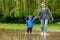 Portrait of cute kid boy playing with handmade ship. kindergarten boy sailing a toy boat by the waters` edge in the park